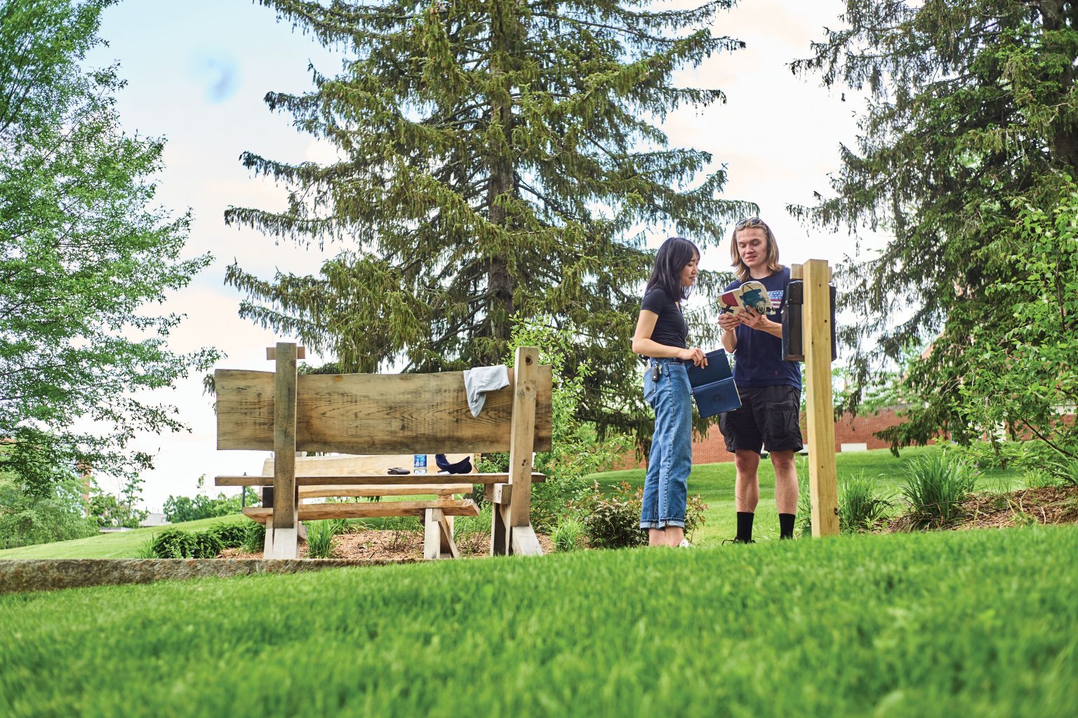 Two students enjoy the new Swing Tree Garden on a bright sunny day